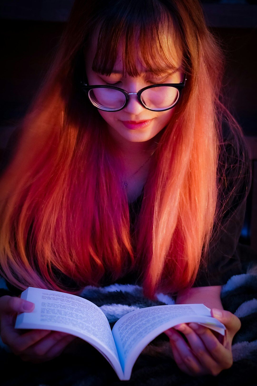 woman reading mystery book at night